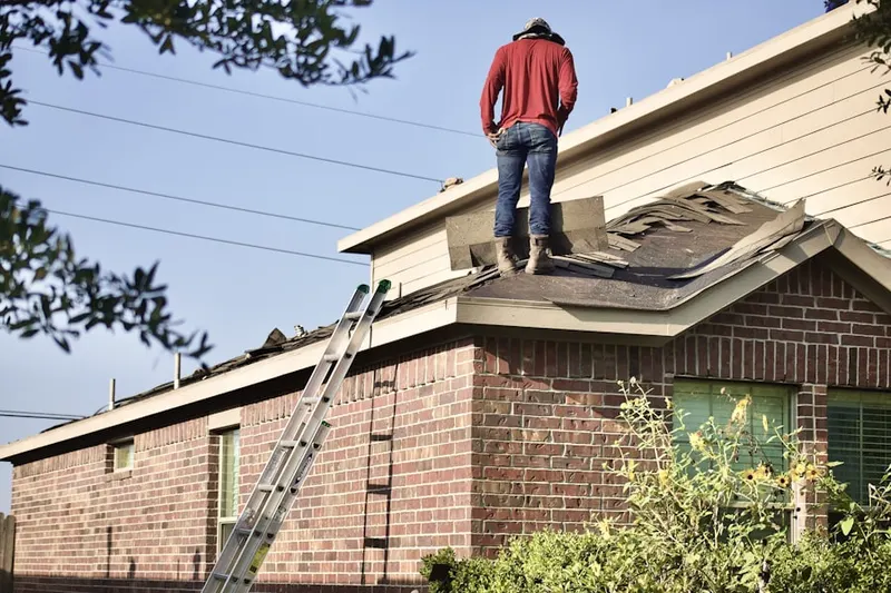 Professional roofer working on a residential roof in Groton